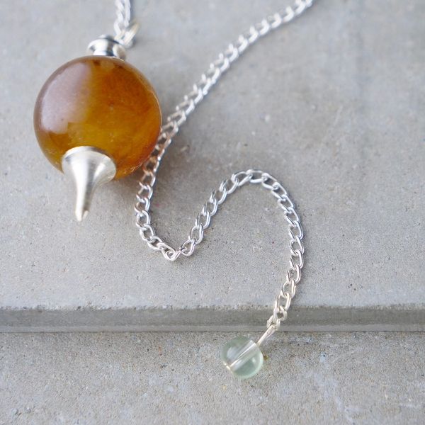 Spheric pendulum with brown onyx stone